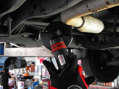 a close up of a person holding a wrench under a vehicle